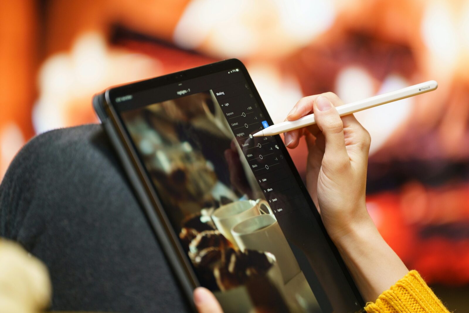 Creating digital art on a tablet with a stylus, cozy by the fireplace.